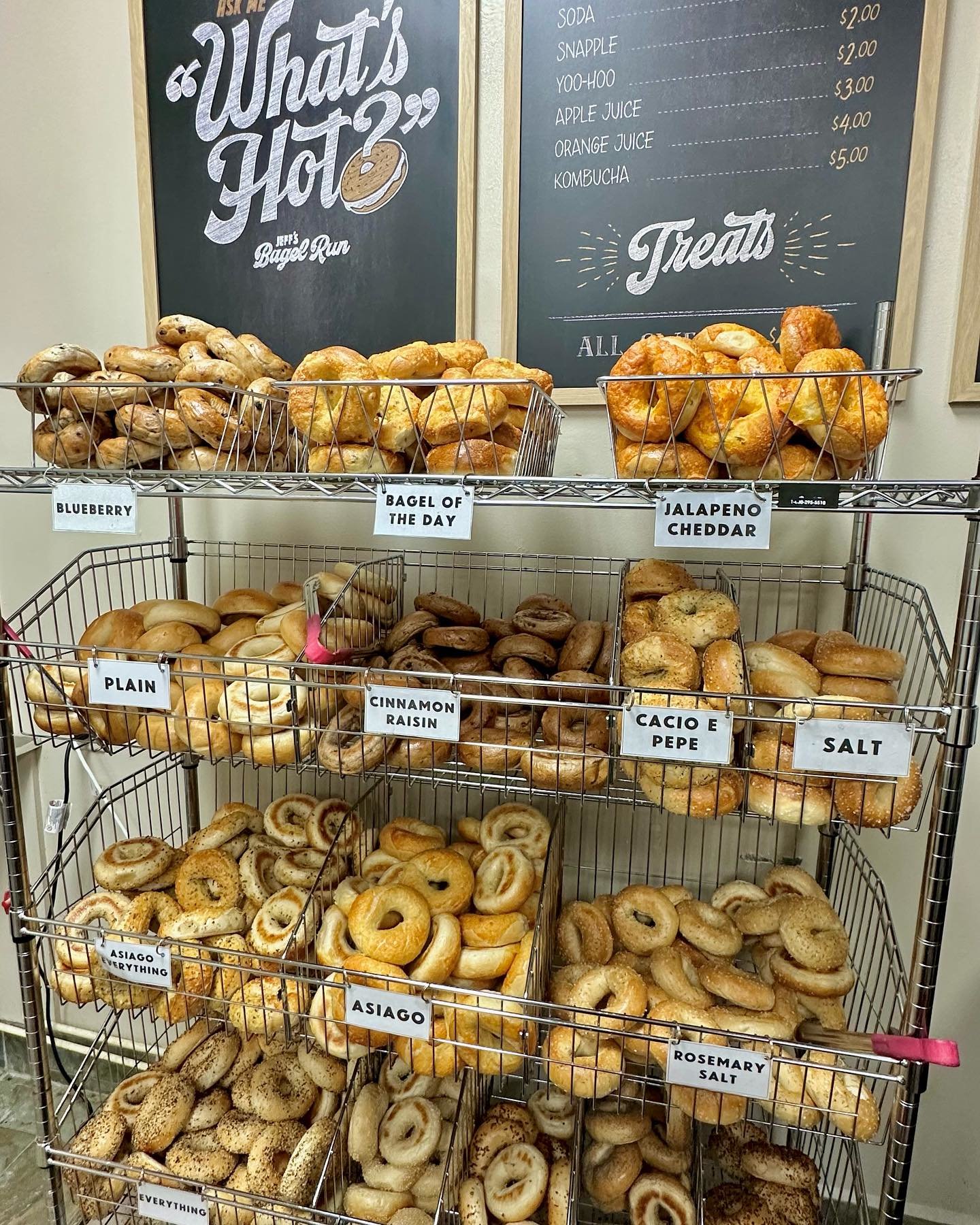 shelf with variety of bagels in metal containers